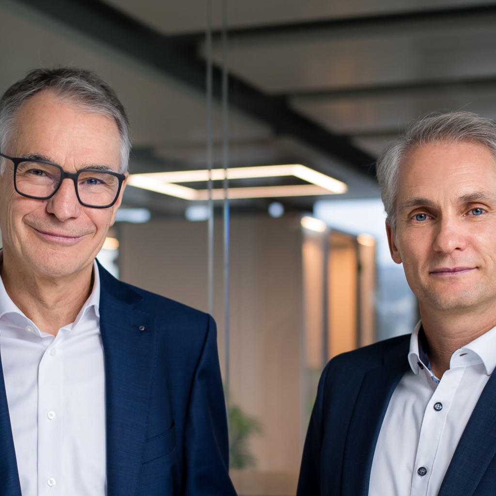 Photo of former CEO Martin Becker and new CEO Alexander Heizler standing together.
