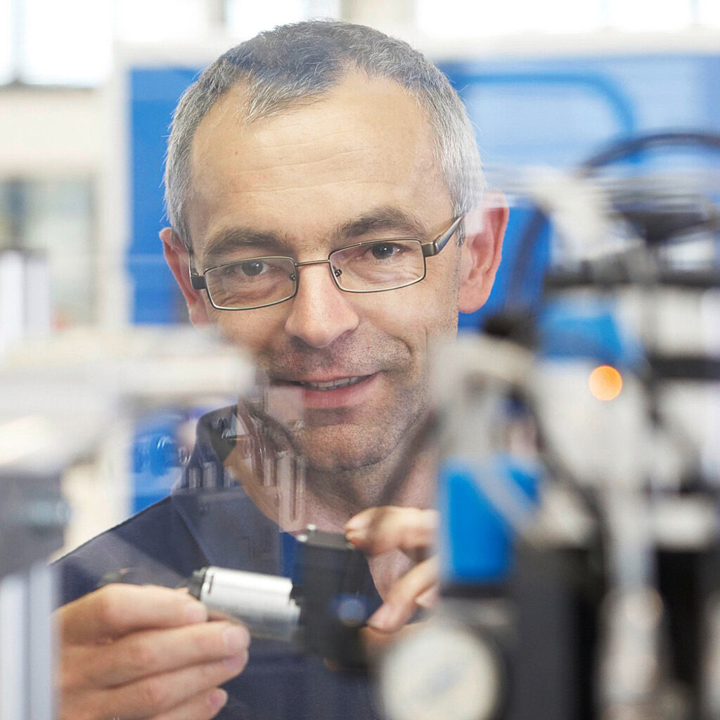 Un ingeniero de KNF mira una bomba de diafragma. KNF fabrica una gran variedad de bombas de diafragma y compresores de pistón.