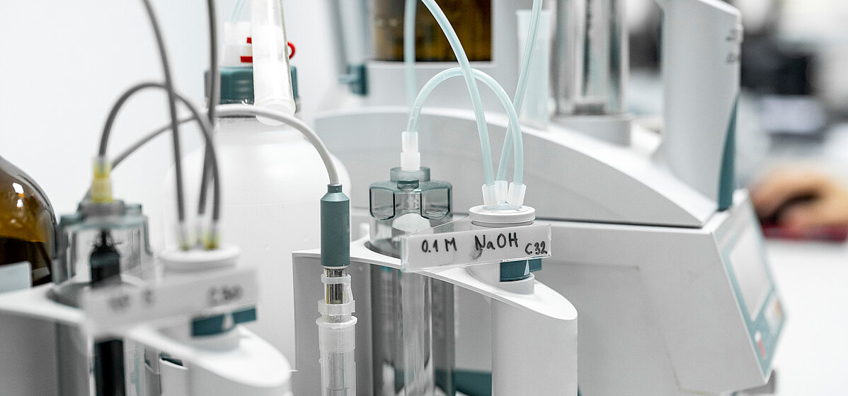 Laboratory equipment setup with various pipes that transfer media from different tubes to an analyzer.