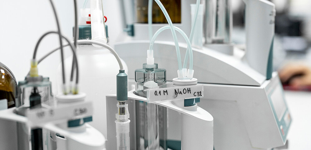 Laboratory equipment setup with various pipes that transfer media from different tubes to an analyzer.